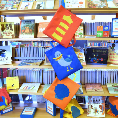 Foto einer Ausstellung des "LeseLachM&ouml;wen"-Projektes: Kinderb&uuml;cher und Stoffbeutel mit maritimen Motiven. 