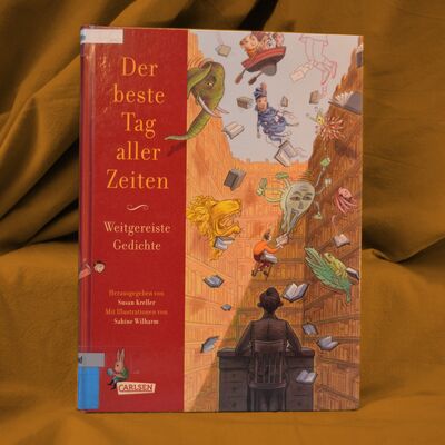 Foto des Buches "Der beste Tag aller Zeiten". Das Buchcover zeigt eine gezeichnete Bibliothek, aus deren Regalen B&uuml;cher, Tiere und literarische Figuren fliegen.