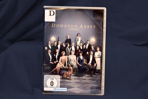 Das Cover der DVD "Downton Abbey - Der Film" vor dunkelblauem Grund.