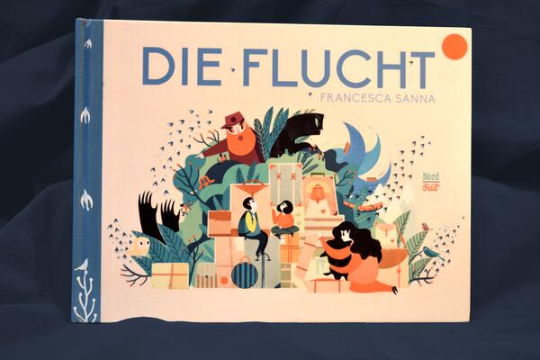 Foto des Buchs "Die Flucht". Das Cover zeigt viele grafische Details aus dem Inhalt; im Mittelpunkt eine Familie vor Bergen von gepackten Koffern und Kartons.