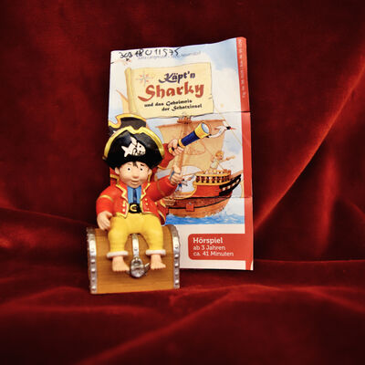 Ein Foto der Tonie-Figur "K&auml;pt'n Sharky". Dahinter das Cover des Tonies.