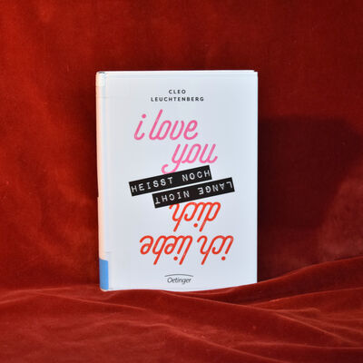 Foto des Buches "Ich love you hei&szlig;t noch lange nicht ich liebe dich". Das Cover zeigt den Titel vor wei&szlig;em Hintergrund. Die Ausrichtung der Schrift wechselt in der Mitte des Titels - die erste H&auml;lfte "I love you hei&szlig;t noch" ist von oben nach unten zu lesen, die zweite H&auml;lfte "lange nicht ich liebe dich" steht auf dem Kopf.