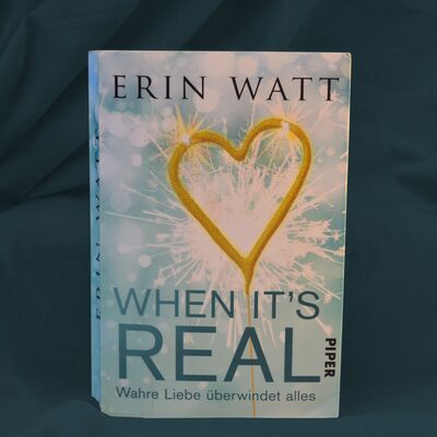 Foto des Buches "When it's real". Das Buchcover zeigt eine funkenspr&uuml;hende Wunderkerze in Herzform.
