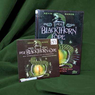 Foto des Buchs und H&ouml;rbuchs "Der Blackthorn-Code - das Verm&auml;chtnis des Alchemisten". Das Cover zeigt ein bauchiges Glasgef&auml;&szlig;, um das sich eine Schlange windet. Im Inneren des Glases ist ein helles Licht zu erkennen, davor die Silhouette eines Jungen.