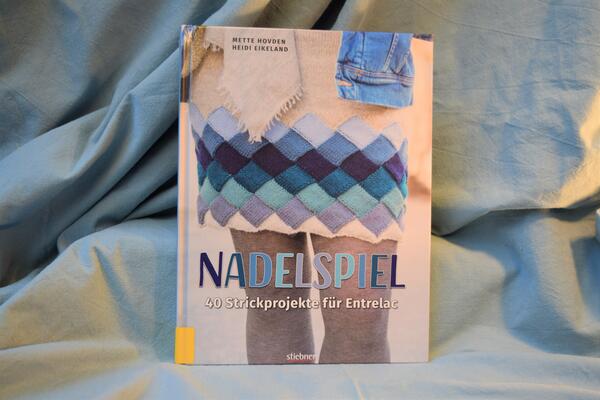 Foto des Buches "Nadelspiel". Das Cover zeigt als Beispiel einen gestrickten Rock.