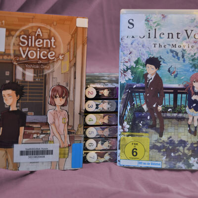 Foto der siebenb&auml;ndigen Mangareihe "A silent voice" und der gleichnamigen DVD. Auf dem Cover des ersten Bandes und dem Cover der DVD sind jeweils die beiden Hauptfiguren Shoya und Shoko zu sehen - beim Manga als Kinder in der Grundschule, beim Film als Jugendliche auf einer Br&uuml;cke.
