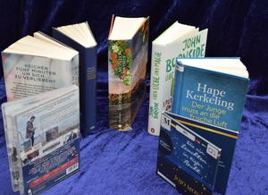 5 B&uuml;cher, eine DVD und ein H&ouml;rbuch sind kreisf&ouml;rmig aufgestellt, wobei vorne eine L&uuml;cke bleibt.
