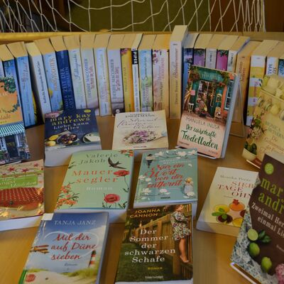 Foto des B&uuml;chertisches zum Motto "Sommer, Sonne, Meer" mit vielen thematisch passenden Taschenb&uuml;chern.