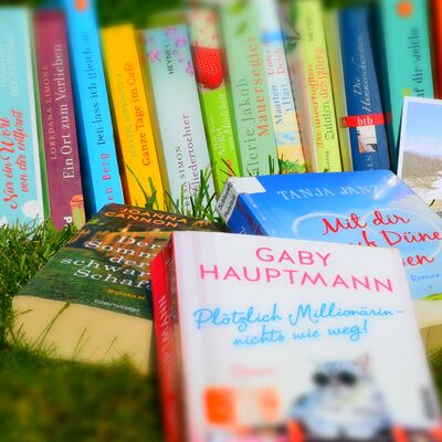 Nahaufnahme einiger Taschenb&uuml;cher drau&szlig;en im Gras, rund um Sommer und Urlaub.