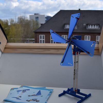 Foto einer Lego-Windm&uuml;hle, die auf einem Fensterbrett steht. Neben der Windm&uuml;hle liegt die Aufbau-Anleitung.