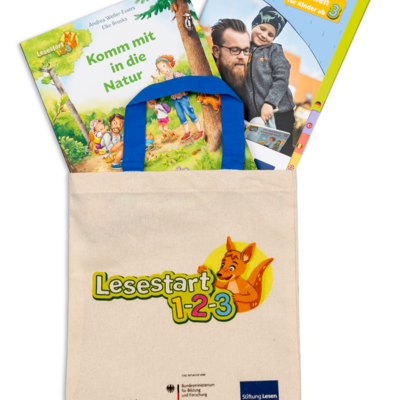Foto einer Lesestart-Tasche, aus der ein altersgerechtes Bilderbuch sowie eine Brosch&uuml;re mit Informationen f&uuml;r Eltern herausschauen.