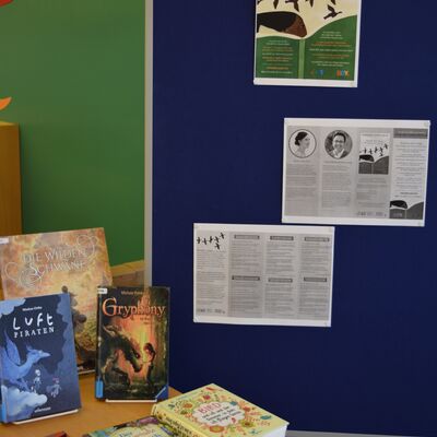 Das Foto zeigt eine Stellwand mit Plakat und Infomaterial sowie einen Teil des B&uuml;chertisches zum Internationalen Kinderbuchtag 2022.