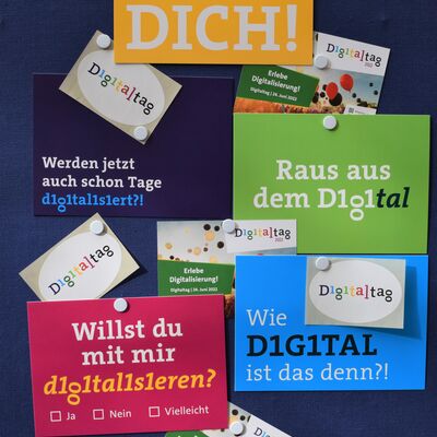 Foto mehrerer unterschiedlicher Postkarten und Aufkleber zum Digitaltag