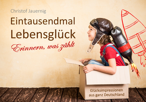 Die Abbildung zu "Eintausendmal Lebensgl&uuml;ck" von Christof Jauernig zeigt ein Kind mit Pilotenkappe und einer selbstgebastelten "Rakete" als Rucksack, das startbereit in einem Pappkarton sitzt.