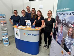 Das Foto zeigt den Messestand der Husumer Stadtverwaltung auf der vocatium und einen Teil des st&auml;dtischen Messe-Teams.