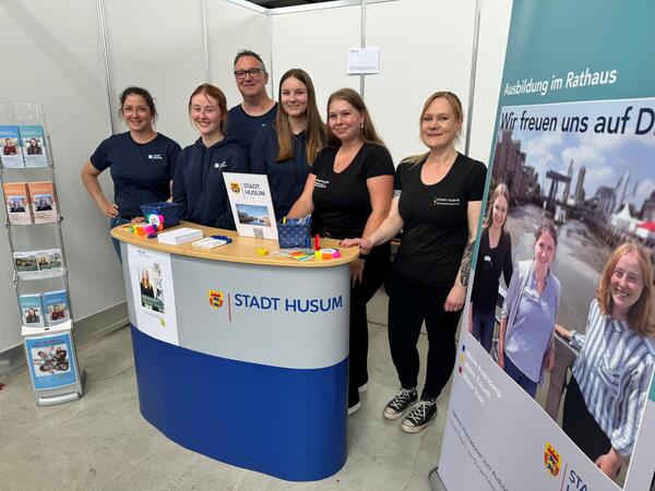 Das Foto zeigt den Messestand der Husumer Stadtverwaltung auf der vocatium und einen Teil des st&auml;dtischen Messe-Teams.